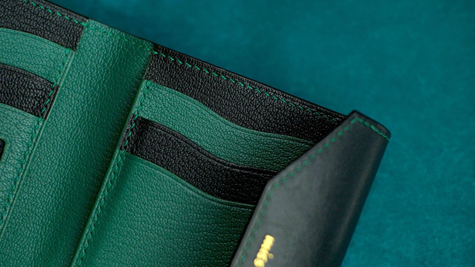 Dark leather wallet on black leather surface